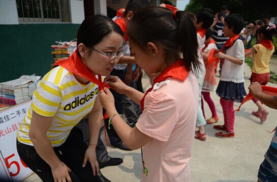 捐贈儀式上，孩子們?yōu)閻坌奶焓瓜瞪霞t領(lǐng)巾