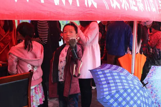 因?yàn)橛晗碌奶?，小男孩玩起了接水游戲? complete=