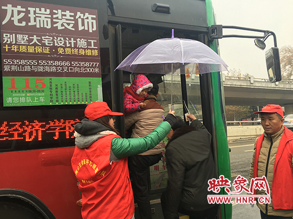 志愿者幫助乘客乘車(chē)