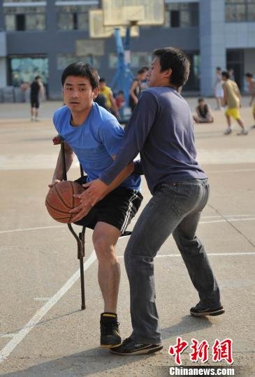 圖為拄著拐杖的瞿詩(shī)濤和同學(xué)搶球。劉占昆攝