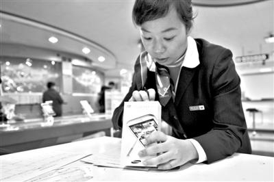 11月6日，北京移動(dòng)西直門營業(yè)廳的工作人員在為顧客購買的4G手機(jī)登記。新華社發(fā)