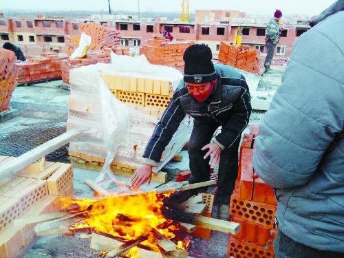 在俄羅斯工地打工時(shí)，因?yàn)樘焯?，工人不得不在工地生火取暖。（圖由方先生提供）