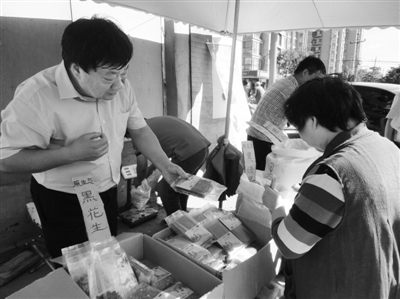 昨日，河南企業(yè)家劉春喜在京“練攤”，為顧客挑選綠豆。新京報記者 張玉學(xué) 攝