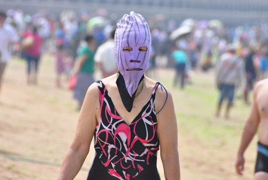 2013年7月3日，山東青島青島高溫來襲，“青島大媽”不懼滸苔，戴著“強盜面具”出現在海水浴場消暑降