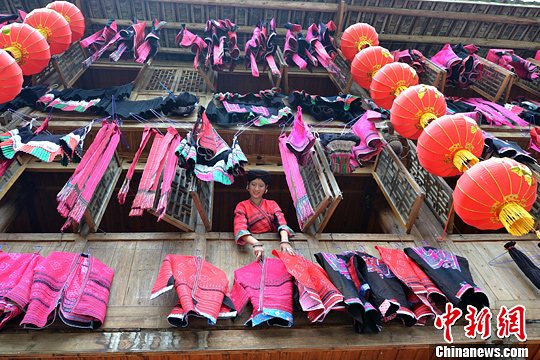 圖為紅瑤姑娘把紅衣晾曬出來。中新社發(fā) 韋吉陽 攝