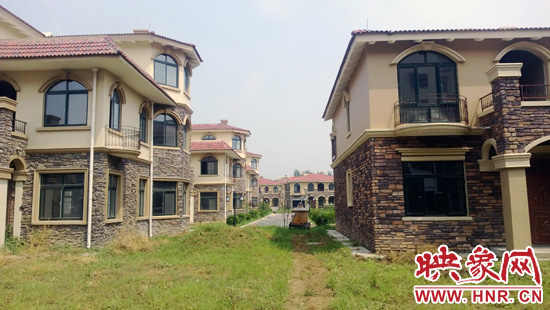 圖為別墅群內(nèi)正在進行最后的鋪路、綠化