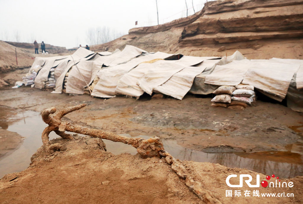 2014年1月6日，河南洛陽(yáng)古沉船發(fā)掘現(xiàn)場(chǎng)，古沉船鐵錨從見(jiàn)天日，靜靜地躺在古船旁。