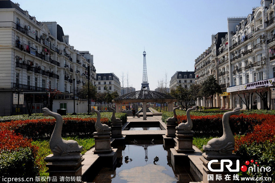 　2014年3月21日，杭州天都城，農(nóng)民在山寨埃菲爾鐵塔下耕作。圖片來源：東方IC