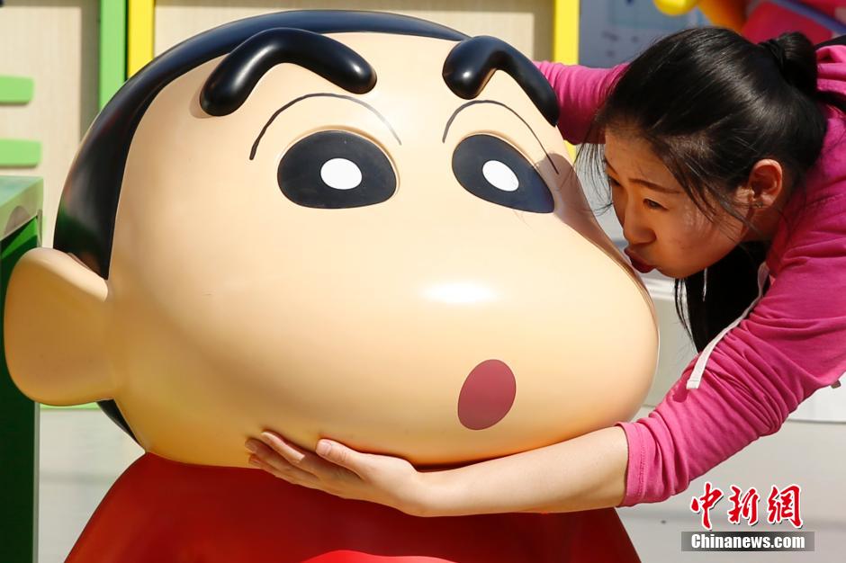 4月22日，游客與蠟筆小新合影。“蠟筆小新25周年紀念特展”日前在北京開展，吸引了不少市民游客。