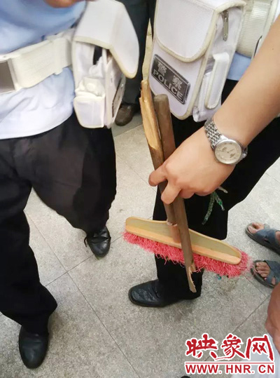 老太從環(huán)衛(wèi)工手中奪過掃帚，用腳踩斷，用力向環(huán)衛(wèi)工人的手上和腿上敲去。