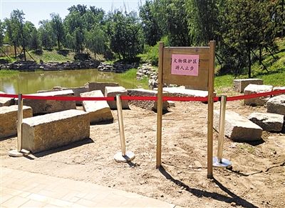 圓明園規(guī)月橋橋體構(gòu)件區(qū)域的警戒線和提示牌。 新京報(bào)記者 鄧琦 攝