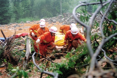 昨日，消防隊(duì)員在四川省都江堰市中興鎮(zhèn)三溪村滑坡現(xiàn)場(chǎng)運(yùn)送遇難者遺體。新華社記者 薛玉斌 攝