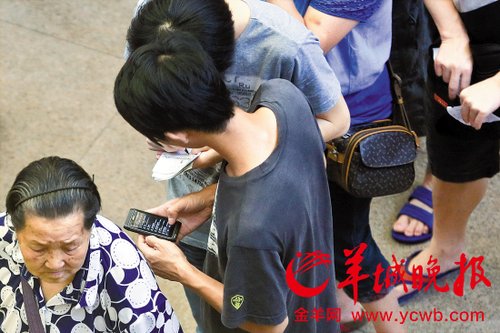 排隊(duì)的“黃?！备魇謭?zhí)一疊白紙，上面寫好了要掛號(hào)的人的信息，包括姓名、電話、要掛的科室等。穿黑白花紋衣服的老婆婆正在排隊(duì)掛號(hào)