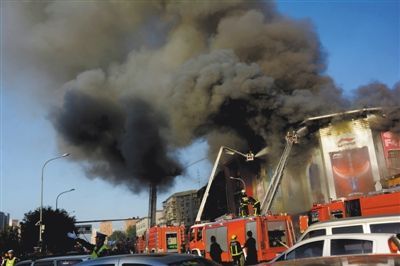 11日，蘋果園喜隆多商場(chǎng)，火災(zāi)現(xiàn)場(chǎng)濃煙滾滾。新華社發(fā)