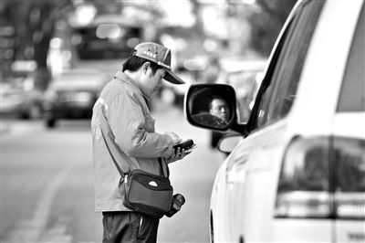 10月15日，朝陽區(qū)東大橋路，停車管理員從腰間掏出一個專用POS機(jī)，正在錄入停車信息。新京報記者 周崗峰 攝