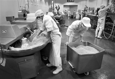 昨日，位于順義李遂開發(fā)區(qū)的慶豐包子鋪配送中心生產(chǎn)車間，工人們正在斬拌胡蘿卜餡料。