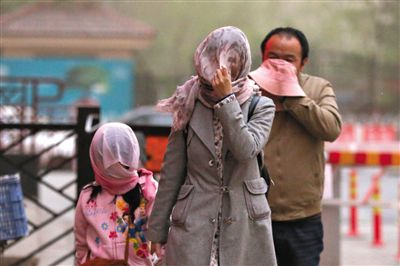 昨日下午，朝陽(yáng)區(qū)豆各莊，行人將紗巾裹在頭上防沙塵。