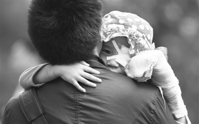 昨日，北京同仁醫(yī)院，被砍傷的彤彤趴在舅舅的肩上。他們剛剛掛完號，正準備回旅館。新京報記者 尹亞飛 攝