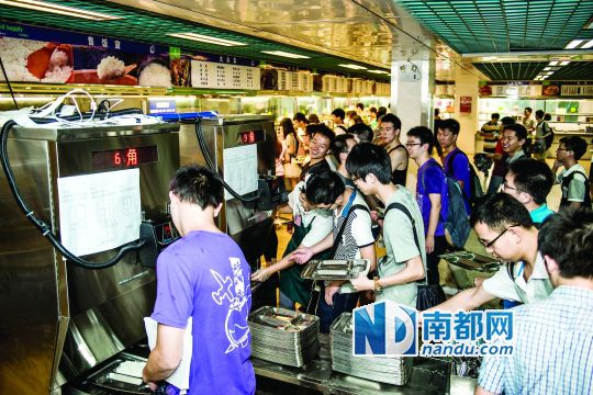 昨日，華南理工大學(xué)一食堂內(nèi)，學(xué)生們正在使用新安裝的自動(dòng)打飯機(jī)打飯。中新社發(fā)