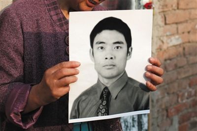 5月19日，朝陽北路，母親捧著張東文的遺像。新京報(bào)記者 侯少卿 攝