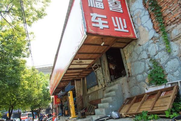 南京一電動(dòng)車(chē)店老板為節(jié)約成本蝸居廣告箱