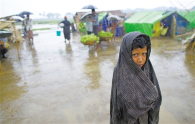 5月14日，緬甸若開邦實兌難民營，羅興亞族難民在雨中行走。熱帶風暴“馬哈森”即將登陸緬甸，這里的難民開始乘船撤離。