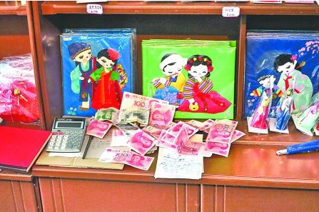　　2012年6月21日，在朝鮮羅先特別市的一家商店里，柜臺上散落著一些人民幣。在朝鮮，人民幣比本國