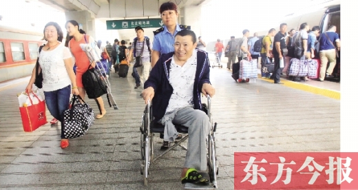 李剛手術(shù)后歸來(lái)，在車(chē)站工作人員幫助下走出鄭州火車(chē)站站臺(tái)  東方今報(bào)首席記者 張曉冬 攝