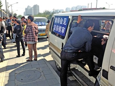 昨日，朝陽區(qū)看守所門前有人排隊。大門外還停有多輛寫有“律師會見”字樣的車。