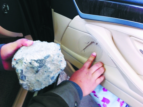 “飛”進寶馬車內的大石塊,將寶馬車的車門內飾板砸爛。