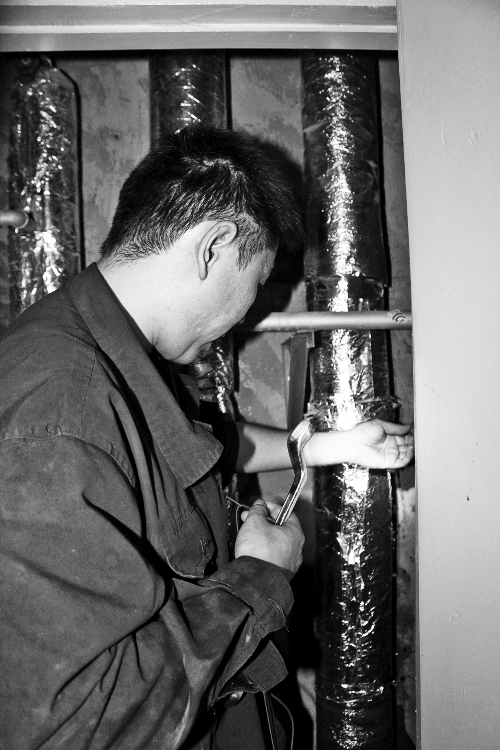 苗師傅一邊進(jìn)行維修，一邊用耳機(jī)接聽市民的電話。