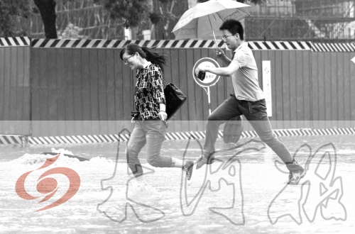 鄭州經(jīng)三路與北環(huán)交叉口處，積水較深，行人們不得不“練輕功”。 記者 白周峰 攝影