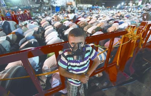 當(dāng)?shù)貢r(shí)間28日晚，在埃及開羅納賽爾城，一名小男孩頭戴防毒面具參加穆兄會(huì)的集會(huì)示威。