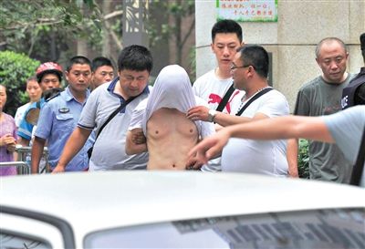 昨日，成都警方抓捕時與毒犯發(fā)生槍戰(zhàn)。一名男犯罪嫌疑人被警方押出。