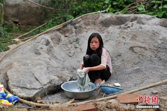 8月9日，云南巧家紅石巖村，10歲的劉鑫蕊在洗自己的衣服