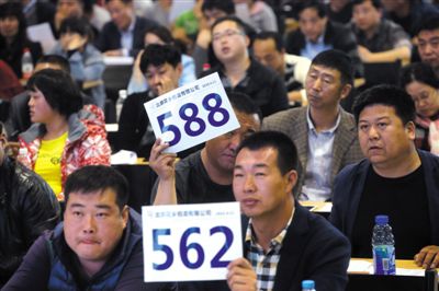 昨日，拍賣現(xiàn)場競拍者舉牌競拍。新京報記者