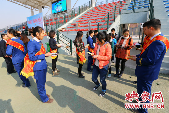 活動(dòng)現(xiàn)場(chǎng)工作人員給同學(xué)們發(fā)放宣傳冊(cè)、環(huán)保袋。