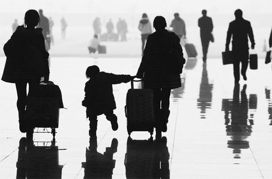 昨日，鄭州東站，一名孩子拉著媽媽和包裹快樂(lè)地奔走在春運(yùn)的途中