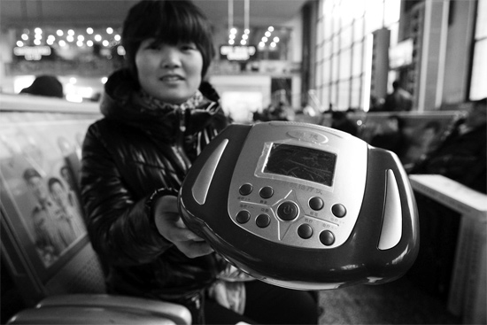 火車(chē)站候車(chē)室，李女士向記者展示她準(zhǔn)備孝敬父母的按摩儀