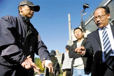 常林鋒在法院外展示雙手，他稱(chēng)被燙傷的手因刑訊逼供且未得到及時(shí)救治