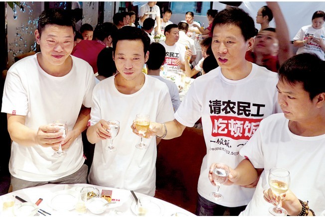 活動(dòng)發(fā)起人張楠（右二）給農(nóng)民工敬酒。