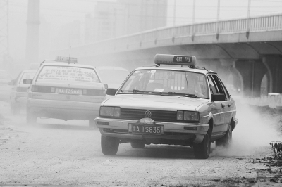 施工的道路上，車輛通過塵土飛揚(yáng)。