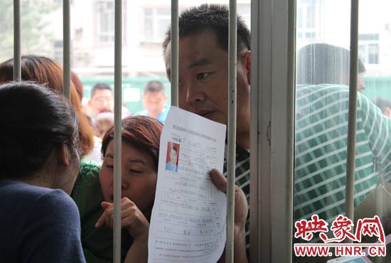 不少家長擠在報名窗口前咨詢報名事宜。