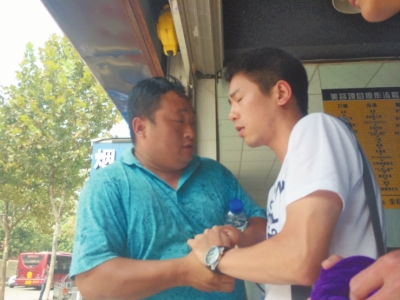 記者正查看照片，突遭藍(lán)衣男強(qiáng)搶手機(jī)。