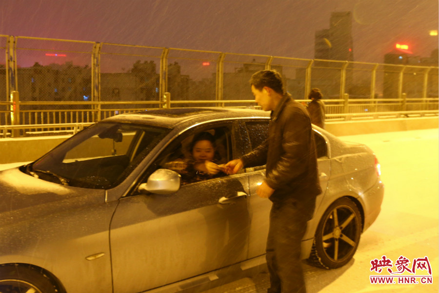 “推車(chē)人”幫助一輛車(chē)上坡后，收取“勞務(wù)費(fèi)”。