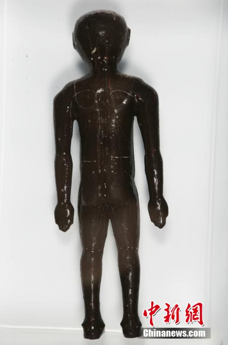 圖為出土的人體經(jīng)穴漆俑。