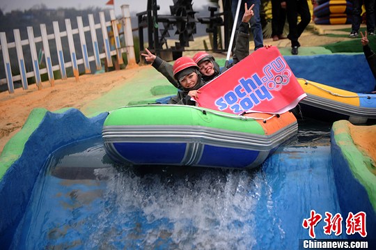 　圖為外國友人舉著標(biāo)語體驗(yàn)水上漂。陳超　攝