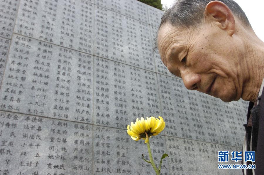 2006年4月5日，74歲的南京大屠殺幸存者佘子清手捧鮮花，祭奠被日軍殺害的母親。