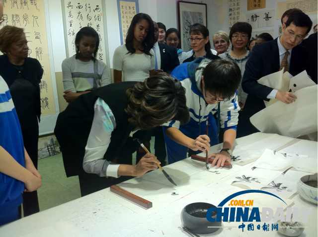 　北京時間3月21日，美國第一夫人米歇爾參觀北師大二附中時，與學(xué)生一起練習(xí)書法。