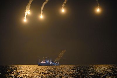 22日，搜救人員在照明彈的光亮下連夜搜救。